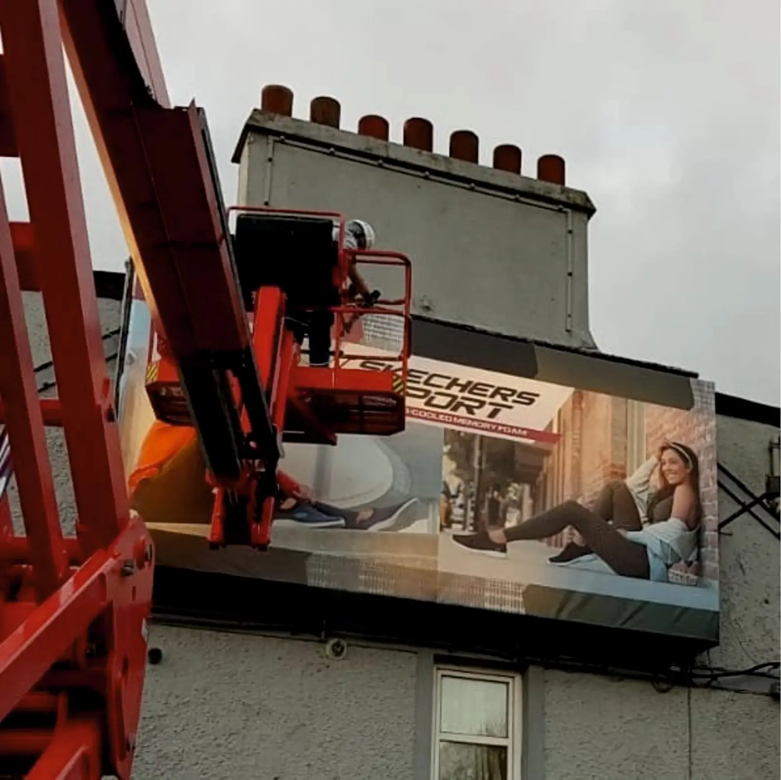Installer replacing a fascia sign from a scissor lift
